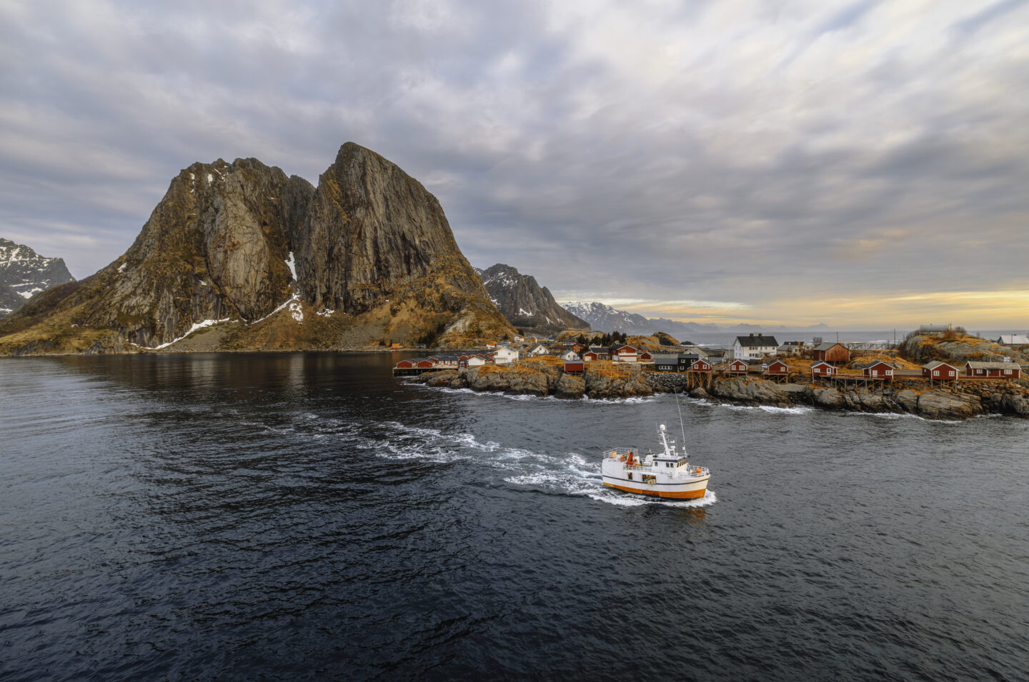 Boat Near Hamnoy Village with Majestic Mountain Backdrop and Fjord Landscape in Lofoten, Norway