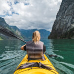 Woman kayaking in fjord in Norway.