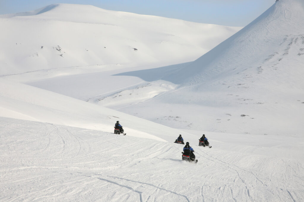 Safari on snowmobiles in arctic mountains of Svalbard, Norway