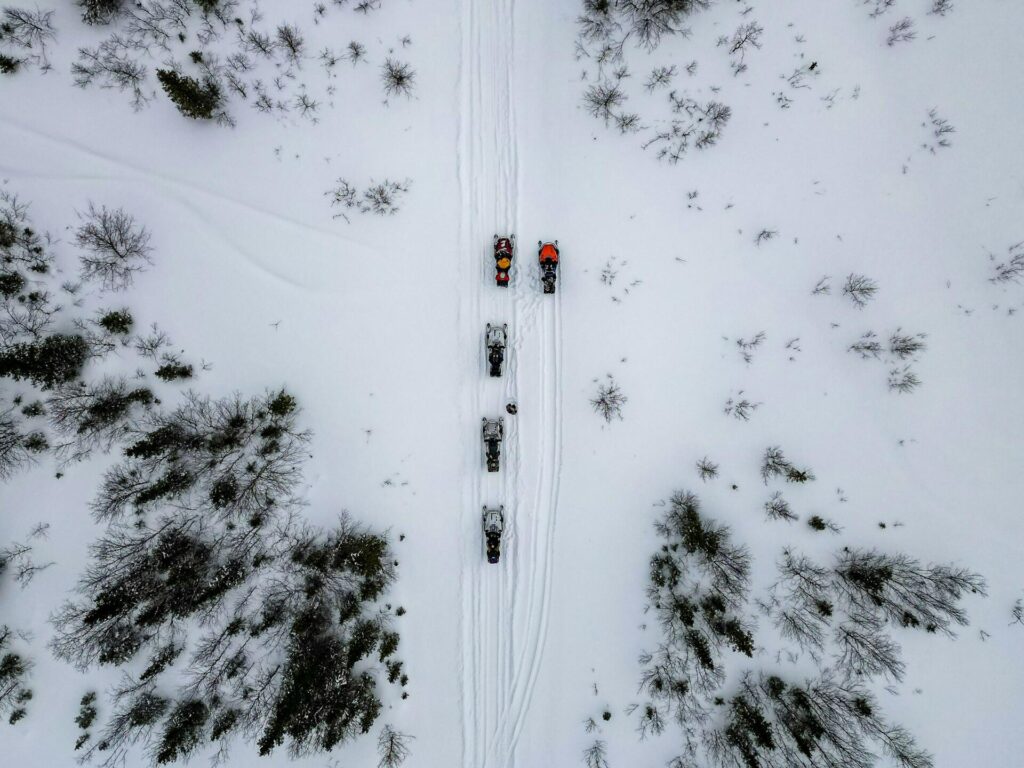 snowmobiles na floresta nevada drone shot leonid-antsiferov-_dMgqAta4CY-unsplash