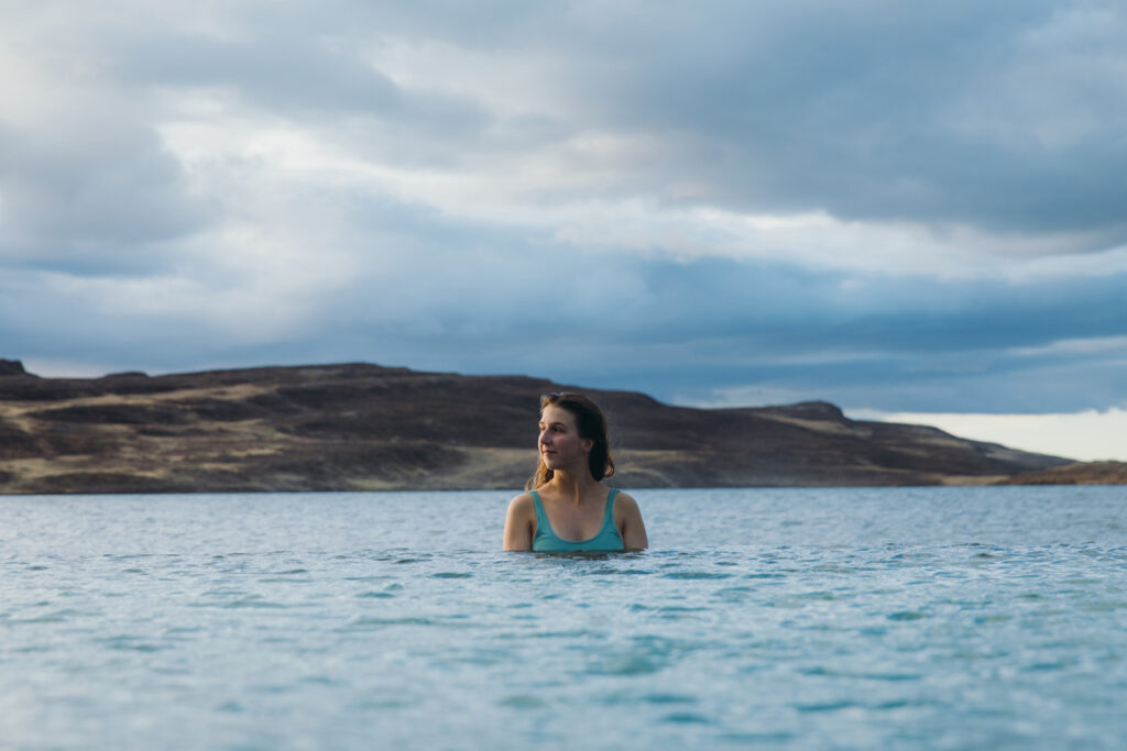 Woman enjoying the bath in thermal swimming pool with lake view in Iceland