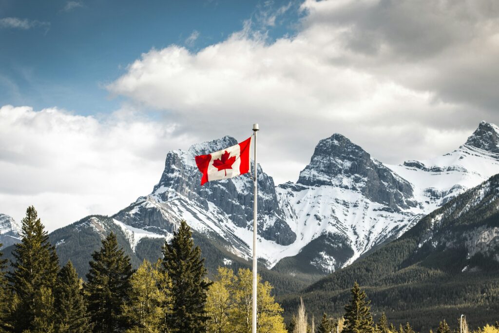 Bandeira do Canadá hasteada com montanhas ao fundo em Alberta