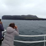 Pessoas fotografam a ilha Surtsey de um barco – Islândia