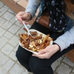 Mulher comendo poutine – Canadá