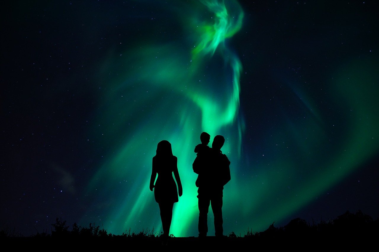Família vendo a aurora boreal com criança