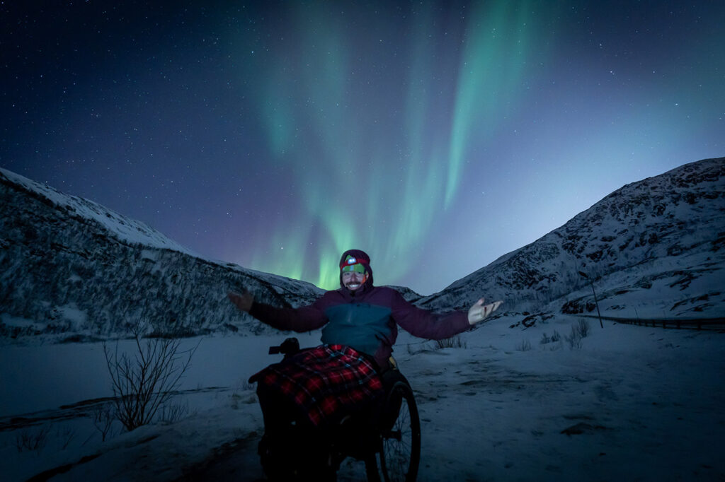 Pessoa em cadeira de rodas durante uma caçadas à Aurora Boreal com acessibilidade.